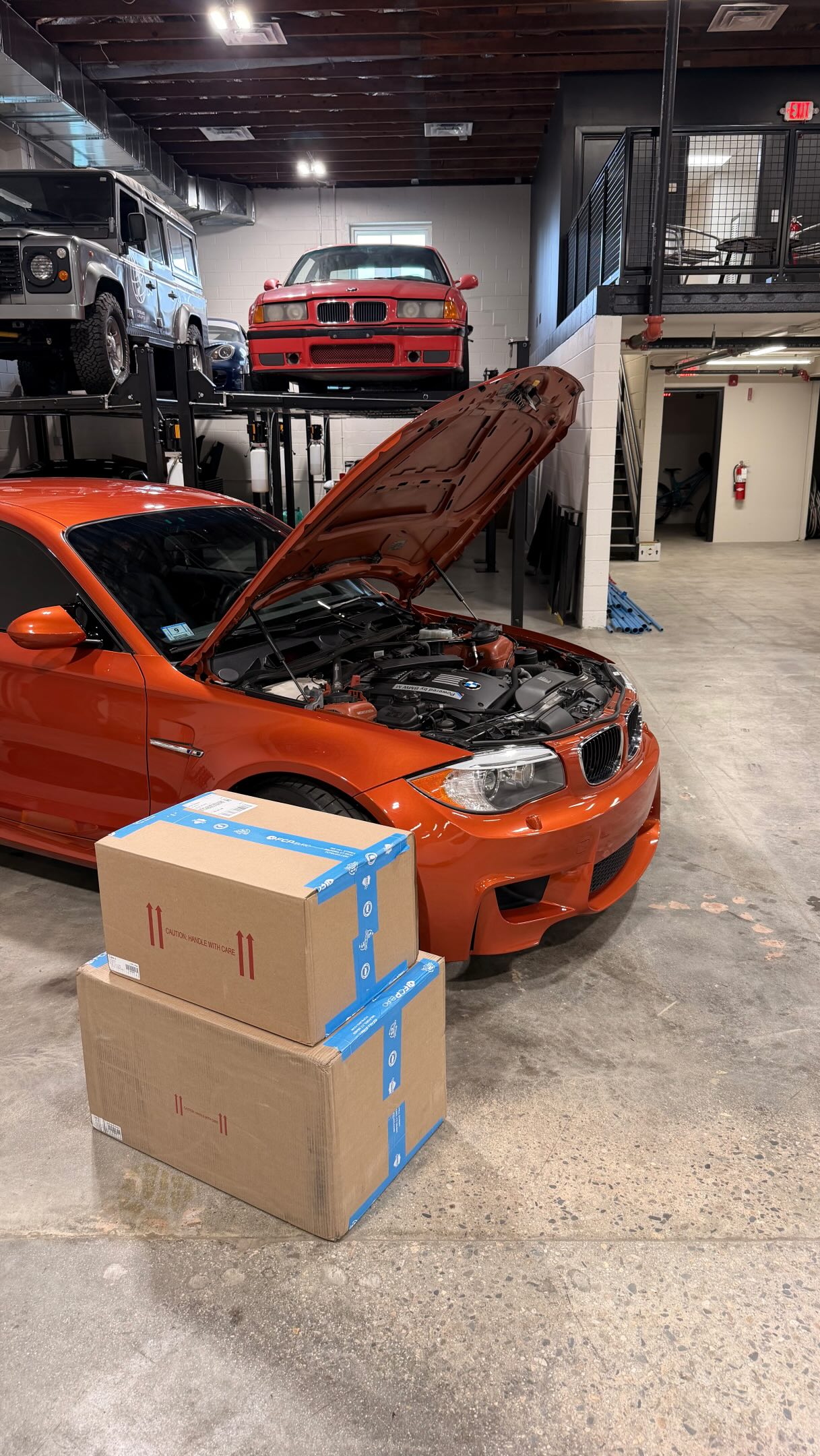 Will wrenching on his Valencia Orange BMW 1M with parts from FCP Euro